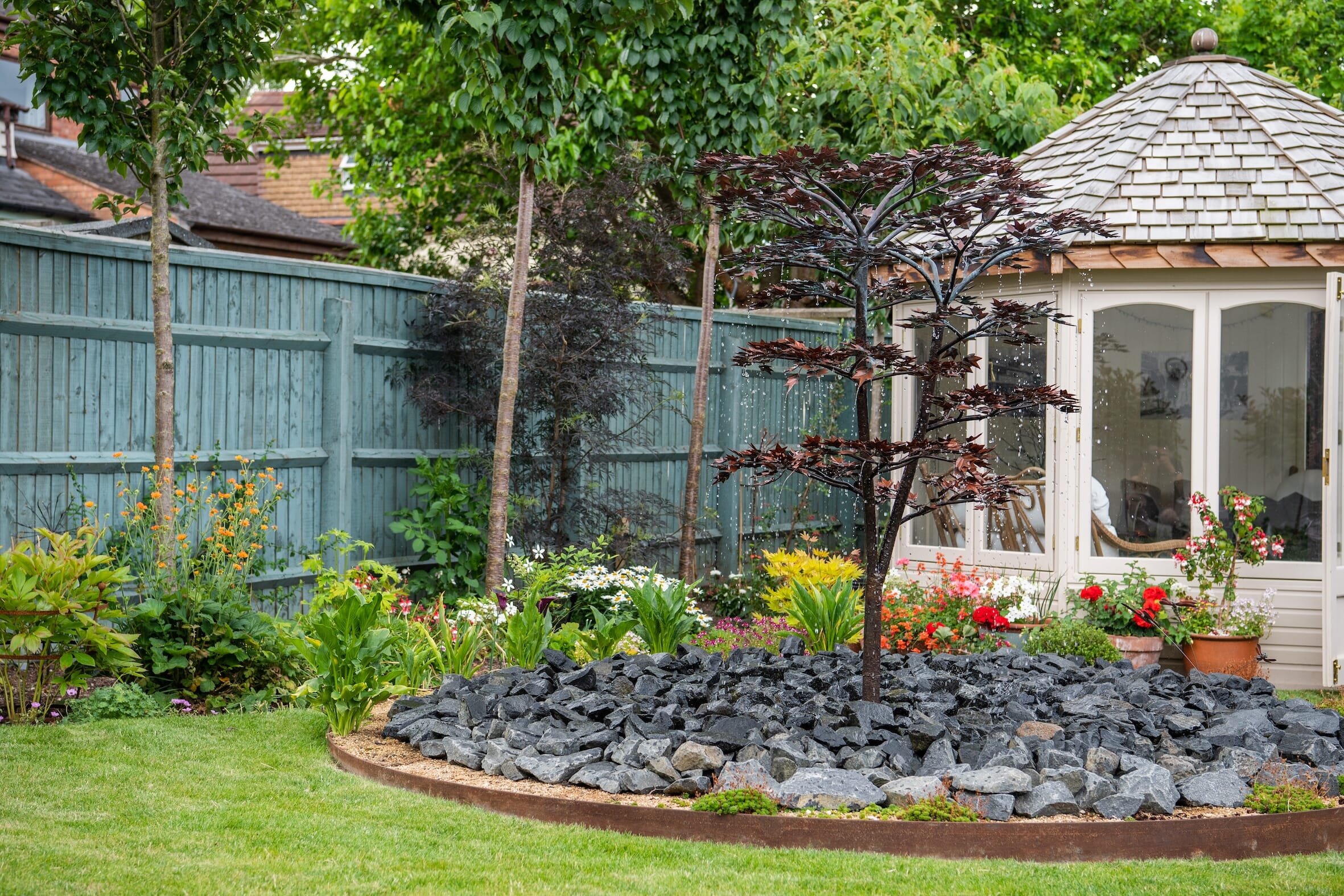 A decorative water features creates a focal point for this luxury garden design in the Cotswolds