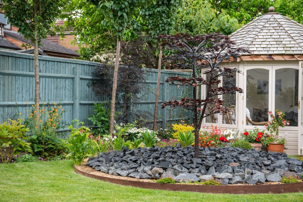 A decorative water features creates a focal point for this luxury garden design in the Cotswolds